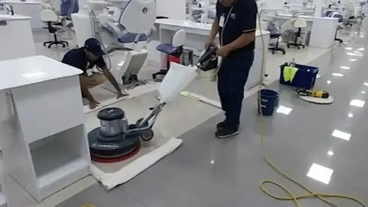 Operarios uniformados realizando el pulido y abrillantado de suelos comerciales con maquinaria rotativa industrial para Klinn.