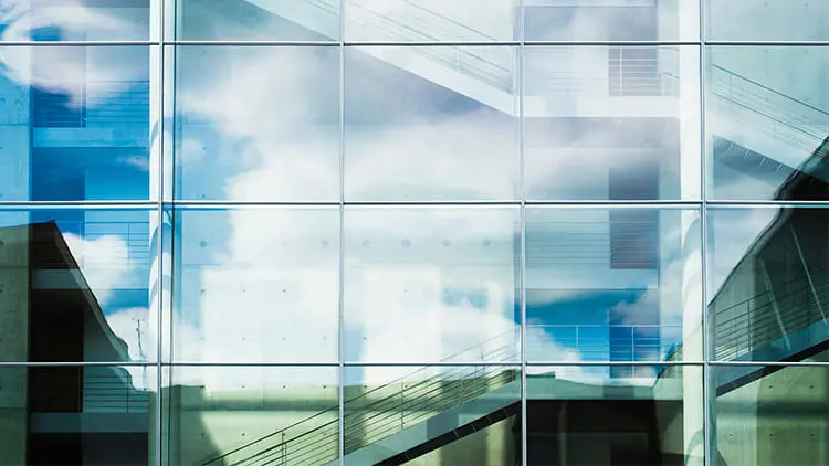Fachada de cristal de un edificio de oficinas impecable y reluciente tras un servicio profesional de limpieza de vidrios de Klinn.
