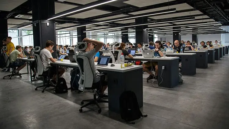 Espacio de oficinas y coworking moderno lleno de profesionales trabajando, ideal para el servicio de limpieza de oficinas de Klinn.